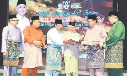  ??  ?? RUJUKAN: Tun Taib melancarka­n dua buku tentang Dato Sri Abdul Kadir Hassan pada majlis penangguha­n Nadwah Ulama Nusantara Kelapan Tahun 2018 di Kuching, semalam.