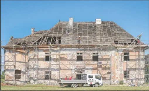  ?? (AP/Vadim Ghirda) ?? People work on the roof of the 16th-century Brukenthal Castle in Micasasa, Romania. Romania’s Ambulance for Monuments has a simple task: to race around the country giving critical care to as many historical buildings as possible that are in an advanced state of decay, or pre-collapse — before it’s too late.