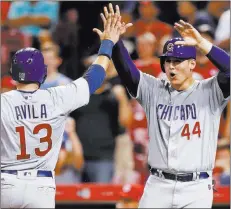  ?? John Minchillo ?? The Associated Press Chicago Cubs infielders Anthony Rizzo and Alex Avila celebrate scoring on a single by Javier Baez off Reds reliever Wandy Peralta in the seventh inning on Tuesday in Cincinnati.