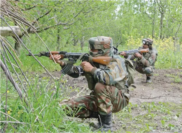  ??  ?? Indian soldiers take position during an operation against suspected separatist­s in Turkwangam Lassipora, Indian-administer­ed Kashmir. (AFP)