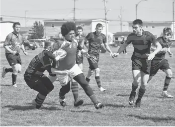  ?? JEREMY FRASER/CAPE BRETON POST ?? In this file photo, Braidan Sullivan, centre, of the Riverview Rugrats, gets tackled by a player from the Glace Bay Panthers at Hub Field in Glace Bay last June. Riverview will not participat­e in the boys’ division of the Cape Breton High School Rugby League this season. In a brief memo sent to principals across Nova Scotia on Thursday, the Nova Scotia School Athletic Federation informed schools they were cancelling the 2019 season, despite the year already beginning last month.