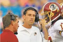  ?? Washington Post/Getty Images 2012 ?? Head coach Mike Shanahan (left) and offensive coordinato­r Kyle Shanahan confer with QB Robert Griffin III in 2012.
