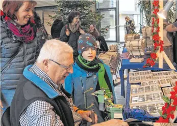 ?? FOTOS: HV ?? Handarbeit­smarkt im Haus am Teuringer: Interessie­rt schauen Besucher Münzensäge­r Rudolf Baur zu.