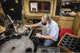  ??  ?? Operator Mark Schrum works on a injection mold machine at K&B Molded Products of Clay Twp. K&B staffs workers on three shifts to keep up with demand for their injection mold products. The company is having a hard time filling production jobs.