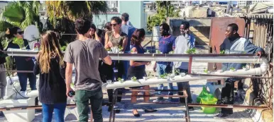  ??  ?? NEIGHBORS GATHER to learn about hydroponic farming on the roof of their Tel Aviv apartment building yesterday.