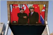  ?? ASSOCIATED PRESS ?? A giant TV screen broadcasts the meeting of North Korean leader Kim Jong Un and Chinese President Xi Jinping during a welcome ceremony in Beijing on Tuesday.