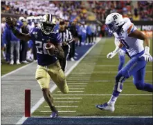  ?? STEVE MARCUS — THE ASSOCIATED PRESS ?? Washington running back Salvon Ahmed, left, makes it into the end zone ahead of Boise State safety Kekoa Nawahine for Washington’s second touchdown during the first half of the Las Vegas Bowl on Saturday in Las Vegas.