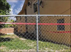  ?? KEVIN D. THOMPSON / THE PALM BEACH POST ?? Red crime-scene tape wraps around a building on North F Street in Lake Worth where a Hispanic man was shot and killed early Saturday.