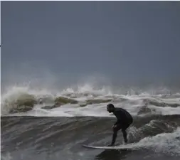  ??  ?? A Lahinch local enjoys the day off work courtesy of Hurricane Ophelia — Irish attitudes to preparatio­ns for a tropical cyclone differ from nations which are used to taking a battering