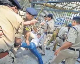  ?? PTI ?? Police officials take away people protesting the CBSE paper leak at Shastri Bhawan on Monday.