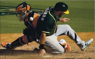  ?? KEVORK DJANSEZIAN — GETTY IMAGES ?? Robbie Grossman slides past the Astros’ Martin Maldonado to score the A’s go-ahead run in the eighth inning on a sacrifice fly from Sean Murphy on Wednesday at Dodger Stadium.