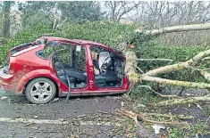  ??  ?? Clockwise from left: Giant waves batter the lighthouse and rocks in Porthcawl, Wales; a car damaged by a tree in an incident which left two men injured in Shropshire; commuter chaos at King’s Cross station in London last night; and a woman on London’s...