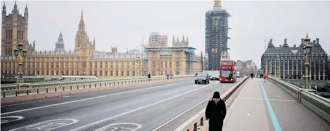  ?? TOLGA AKMEN/AFP–8/1/2021 ?? Quase vazio. Westminste­r Bridge Road, com o Parlamento (E) e o prédio do Big Ben (C) em reforma, tem pouco movimento durante lockdown imposto pelo governo; retomada em março