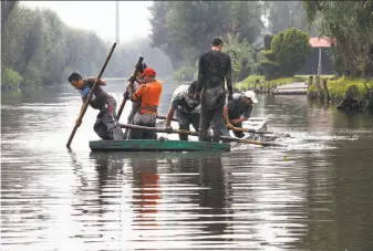  ?? Marco Ugarte / Associated Press ?? Workers remove mud from a shallow canal in Mexico City’s Xochimilco “floating gardens” on July 13. Fecal coliform contaminat­ion affects water fed into the canals by a treatment plant.