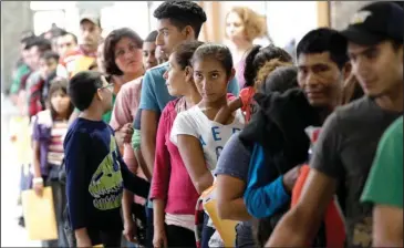  ?? The Associated Press ?? PROCESSING: Immigrants line up inside the bus station after they were processed and released by U.S. Customs and Border Protection on Friday in McAllen, Texas.