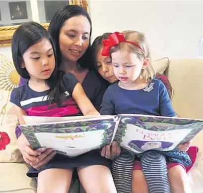  ?? Photo by Denisse Lopez ?? HELEN WANG READS WITH TWO OF HER DAUGHTERS AND HER NIECE.