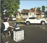  ??  ?? Chester waves to a neighbor driving by May 9 as he performs.