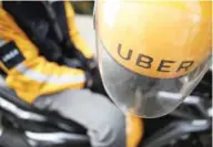  ?? — Reuters ?? An Uber motorcycle taxi driver waits for customers next to a shopping mall in Jakarta.