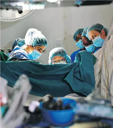  ?? CARL DE SOUZA / AFP / GETTY IMAGES FILES ?? Surgeon Dr. Marci Bowers, centre, performs a clitoral restoratio­n in Nairobi in May. The Canadian Criminal Code deems excising the clitoris aggravated assault.