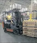  ??  ?? Alan Synder of Washington loads pallets on a forklift at the Washington County facility.