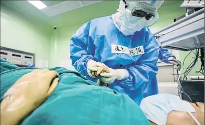  ?? STR / AFP ?? Un doctor en un hospital de Wuhan habla con una embarazada infectada por el coronaviru­s