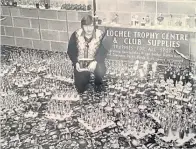  ??  ?? Dundee Sunday Welfare AFA match secretary Jim Don surrounded by the mountain of trophies and medals purchased for the associatio­n’s end-of-season awards.