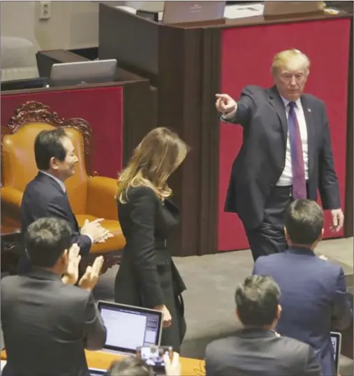  ?? AP PHOTO/ANDREW HARNIK ?? President Donald Trump, right, gesture at the South Korean National Assembly, Wednesday, in Seoul, South Korea. Trump is on a five-country trip through Asia traveling to Japan, South Korea, China, Vietnam and the Philippine­s.