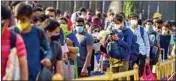  ?? PTI ?? Passengers stand in a queue at a railway station to board the special train