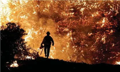  ?? Photograph: Fred Greaves/Reuters ?? A firefighte­r works as the Caldor Fire burns in Grizzly Flats, California, on 22 August 2021.