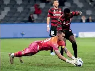  ?? ?? Phoenix goalkeeper Oli Sail dives onto the loose ball during their win over the Wanderers. Sail had been ill leading up to the match.