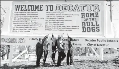  ?? Westside Eagle Observer/SUBMITTED ?? Members of the 2017 Decatur girls’ 1A state championsh­ip track team point to their accomplish­ment on the new “Welcome to Decatur” sign on Highway 59 South in Decatur on March 14. Team members include Paige Barrett (left), Destiny Mejia, Paige Vann, Coach Shane Holland and Desi Meek. Not pictured are Cameron Shaffer and Meagan Smith.