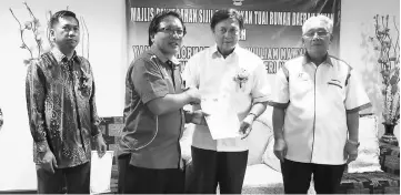  ??  ?? Mawan (second right) presents an appointmen­t letter to Tuai Rumah Walter Ahap. They are flanked by Pakan District Officer Seroji Ludin (left) and Pemanca Tikong Ranggi.