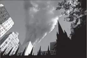  ?? Mario tama/Getty Images/tns ?? Smoke spews from a tower of the World Trade Center on Sept. 11, 2001, after two hijacked airplanes hit the twin towers in a terrorist attack on New York City.