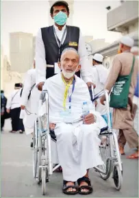  ??  ?? A young Saudi volunteer serves a disabled Hajj pilgrim at the Grand Mosque in Makkah. (SPA)