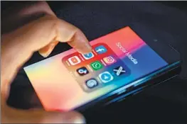  ?? NurPhoto ?? STATE and federal lawmakers are working on regulation­s designed to protect kids on social media, which can be addictive and harmful to their mental health.