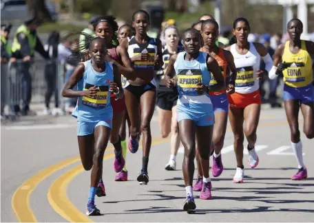  ?? ELiSe ameNDOLa / BOSTON HeraLD ?? LEADER OF THE PACK: The elite women runners compete during the 126th running of the Boston Marathon on Monday in Framingham. At far left is Peres Jepchirchi­r, of Kenya, who won the race in 2 hours, 21 minutes, 1 second.