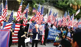  ??  ?? A protester wearing a mask depicting Trump gestures during a ‘March of Gratitude to the US’ event.