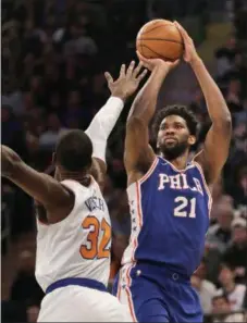  ?? SETH WENIG — THE ASSOCIATED PRESS ?? Joel Embiid shoots over Knicks forward Noah Vonleh during the first half Sunday. Embiid scored 26 points in a 108-105 Sixers win.