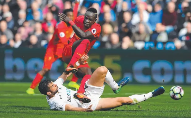  ?? Picture: GETTY ?? DAYLIGHT ROBBERY: Swansea’s Jordi Amat slides in to steal possession from Liverpool’s Sadio Mane during the Premier League match at Swansea.