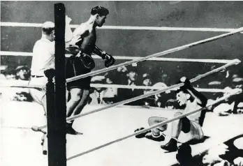  ?? FILE ?? Jack Dempsey, centre, knocks down heavyweigh­t champion Gene Tunney, right, in their title bout at Soldier’s Field in Chicago on Sept. 22, 1927. The fight is known as “The Long Count.”