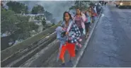  ?? AP PHOTO/MOISES CASTILLO ?? Honduran migrants leave Guatemala City at sunrise Thursday as they make their way north toward the U.S.