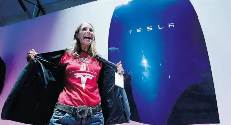  ?? Kevork Djansezian/ Getty Images ?? A guest poses with the Powerwall — a suite of batteries for homes, businesses, and utilities — unveiled by Tesla CEO Elon Musk,
