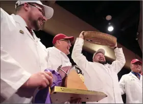  ?? (AP/Wisconsin State Journal/John Hart) ?? Christian Schmutz with the Swiss Cheesemake­rs Associatio­n hoists the 77-pound wheel of gruyere that won Best of Show at this week’s World Championsh­ip Cheese Contest in Madison, Wis.