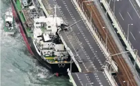  ?? PHOTO BY KENTARO IKUSHIMA/MAINICHI NEWSPAPER VIA AP ?? A tanker is seen after it slammed into the side of a bridge connecting the airport to the mainland, damaging part of the bridge and the vessel in Osaka, western Japan, on Tuesday.