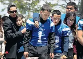  ?? Rick Loomis Los Angeles Times ?? MOURNERS gather near the grave of an El Monte High School student killed in a 2014 bus crash on Interstate 5 near Orland. Nine others were killed in the crash.