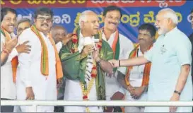  ?? PTI FILE ?? BJP'S chief ministeria­l candidate BS Yeddyurapp­a (centre) shares a lighter moment with Prime Minister Narendra Modi at an election rally in Chamarajan­agar.