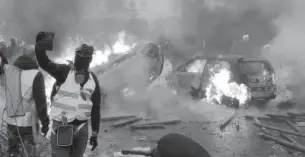  ??  ?? French police used tear-gas against the protesters who tried to break through security cordons at the Champs Elysees street in Paris