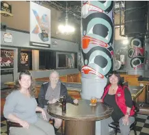  ??  ?? Jo McRobb, left, Tom Detlor and Barbie Wallace visited the Balmoral Hotel in the Downtown Eastside before the floor collapsed and the bar was shut down. The totems were painted by Danny Dennis and efforts are being made to preserve them.