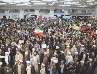  ?? AP PHOTOS ?? DEMANDING CHANGE: Thousands of demonstrat­ors took to the streets in several Iranian cities, including Tehran, above. At right, a university student eludes a smoke grenade.