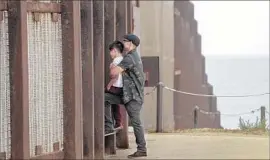  ?? Irfan Khan Los Angeles Times ?? ON THE U.S. side, Andres Gallegos holds his son Saiid, 10, while talking with his family in Mexico through a mesh fence south of San Diego in 2016.